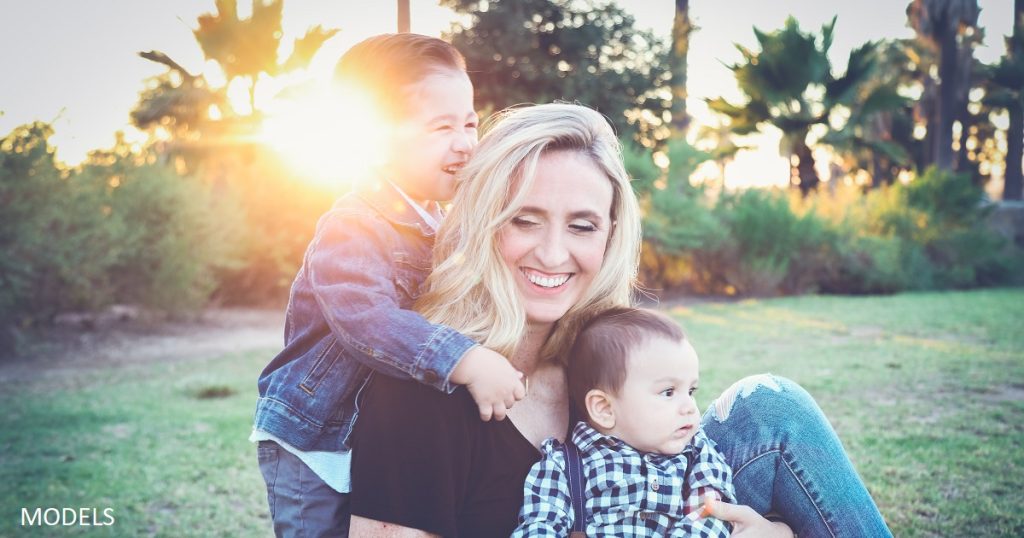 Woman playing with her children after tummy tuck surgery